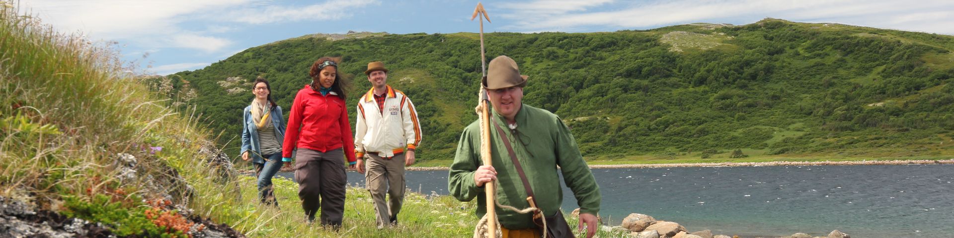 A Parks Canada guide leads a group of 3 visitors on a tour of the coast near Red Bay National Historic Site