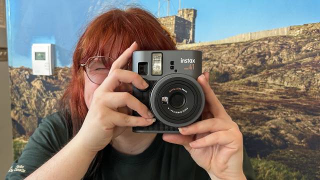 Un employé de Parcs Canada regardant dans un appareil photo instantané.
