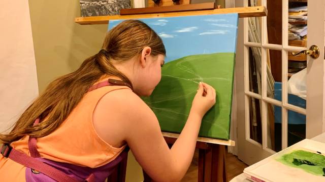 a girl paints on a canvas