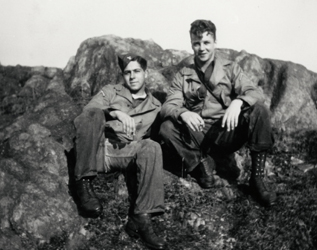 photo en noir et blanc de deux soldats assis sur les rochers