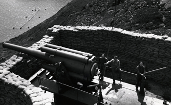 Photo noir et blanc de 3 soldats en train de charger un canon