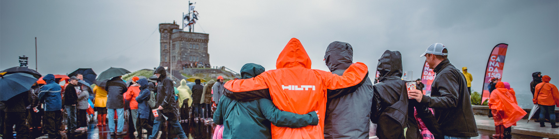 Une foule à côté de la tour Cabot dans la pluie