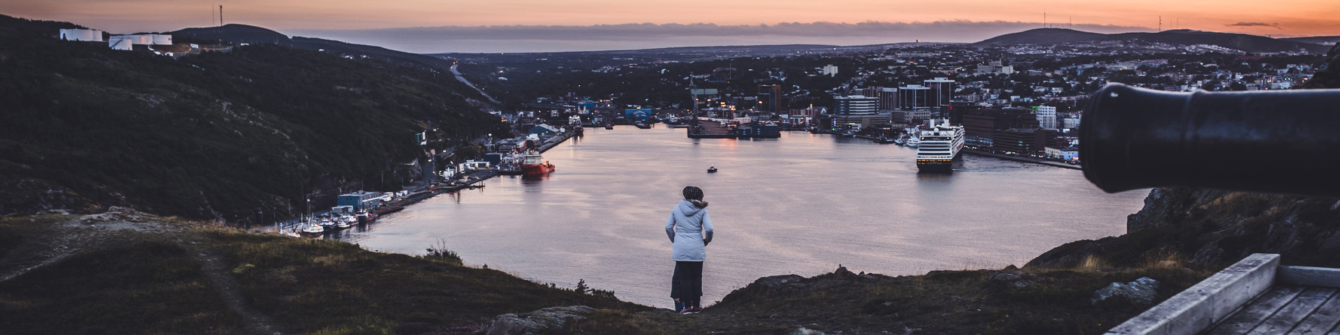 a woman overlooking the city if St. John's at sunset