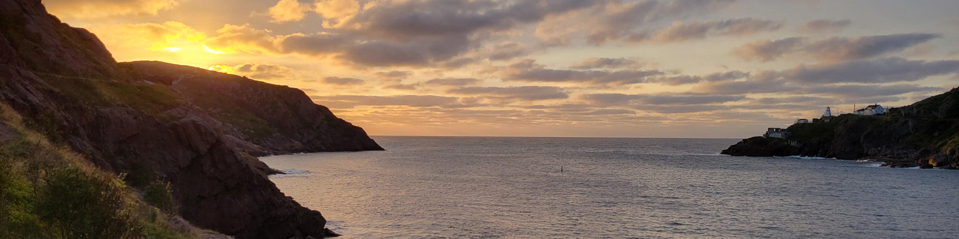 the sun rising over a coastal cliff