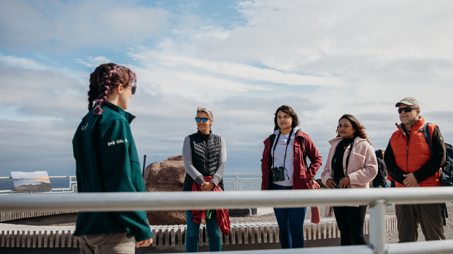 Parks Canada employee guides 4 individuals around the site