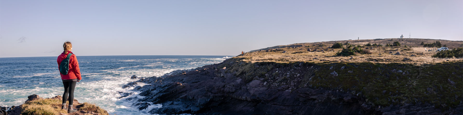 un individu debout sur un sentier côtier surplombant l'océan