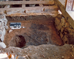 Sous le plancher du blockhaus, une couche de charbon marque l’emplacement original de l’église acadienne de l’Assomption