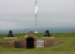 Landscape view of the black hole with two cannons and a flag in the background.