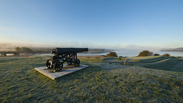 A cannon sits on the grounds overlooking the water at Fort Anne National Historic Site.