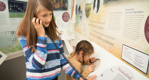 Deux jeunes visiteuses utilisent un audioguide pour découvrir une exposition.