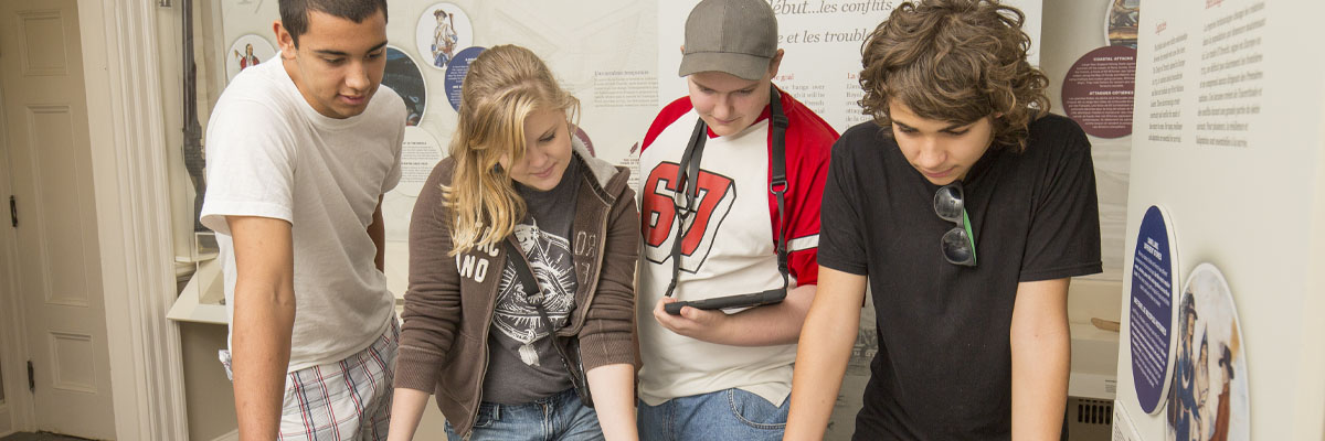 A group of kids interact with an exhibit.