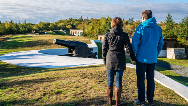 Un couple se tient près d’un canon.  