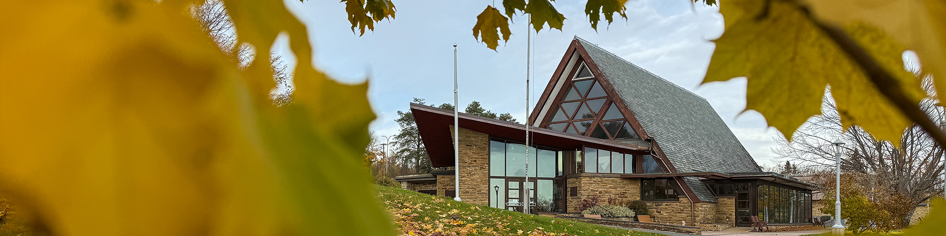 View of the Alexander Graham Bell National Historic Site through the branch of a golden-yellow maple.