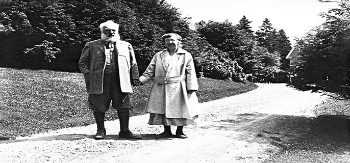 A man and a woman walk while holding hands