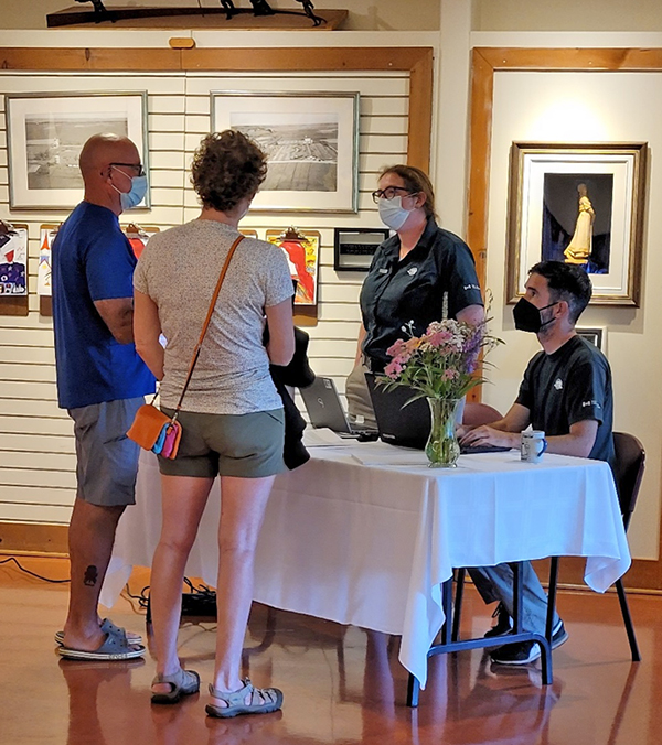 Two members of the public speaking to two Parks Canada employees in Grand-Pré National Historic Site.