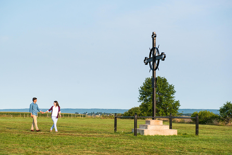 A couple holding hands near the Deprotation Cross at Horton Landing