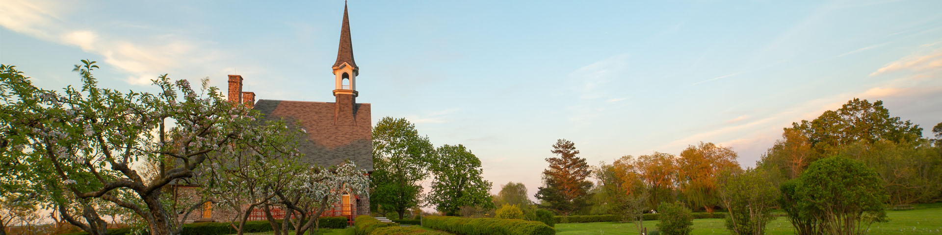 Vue du côté de l'Église-souvenir de Grand-Pré, tout près de pommiers en fleurs dans un jardin victorien.