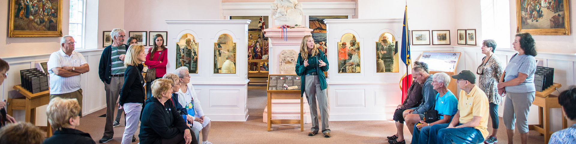 A Parks Canada interpreter talks to a group of visitors inside the Memorial church.