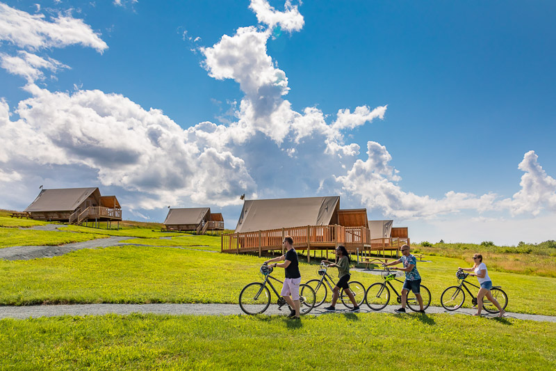 A group of visitors on their bikes near the oTENTik units.