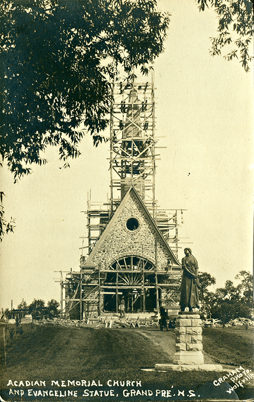 Historic photo of the statue of Evangeline, with the Memorial Church in construction in the background