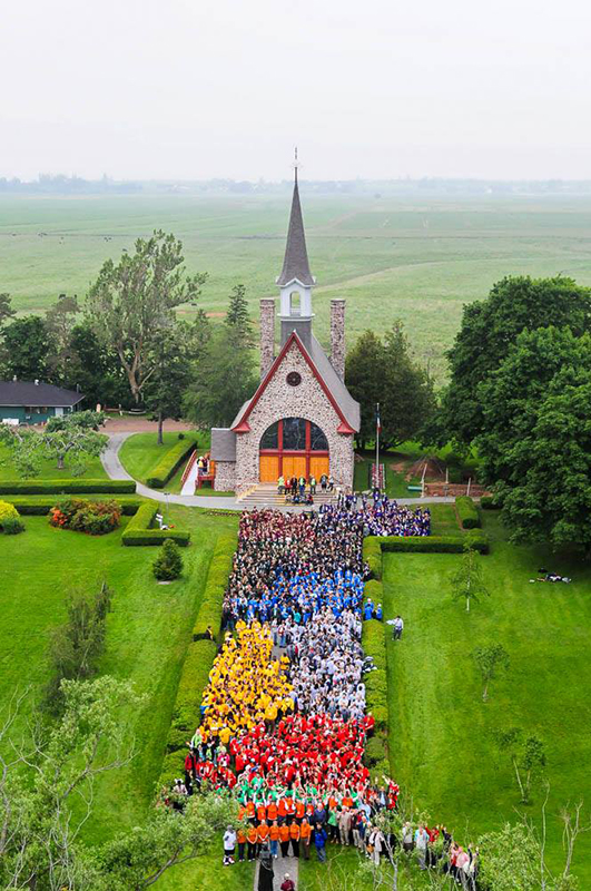 Hundreds of young athletes stand in front of the church
