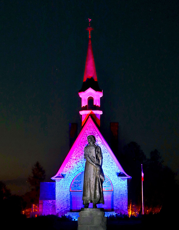 The church is illuminated at night with colourful lights