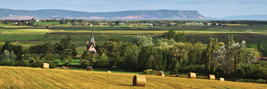 Le paysage de Grand-Pré ou l'on voit l'église souvenir et le Cap Blomidon en arrière-plan