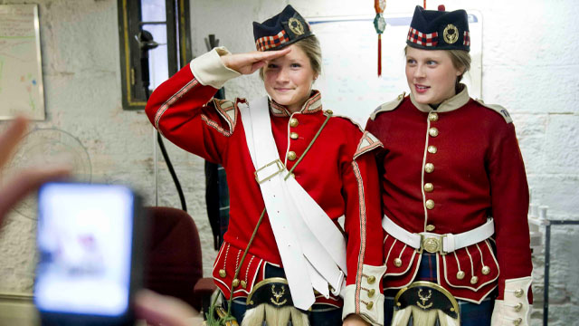 Deux jeunes visiteurs vêtus d’uniformes de soldat.