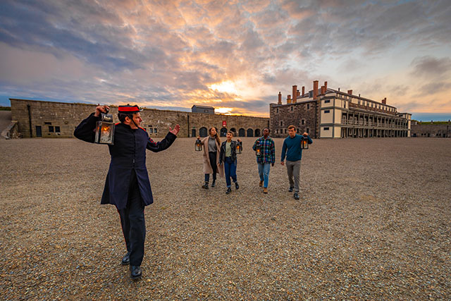 Les visiteurs suivent un interprète historique à travers la vaste place de la Parade.