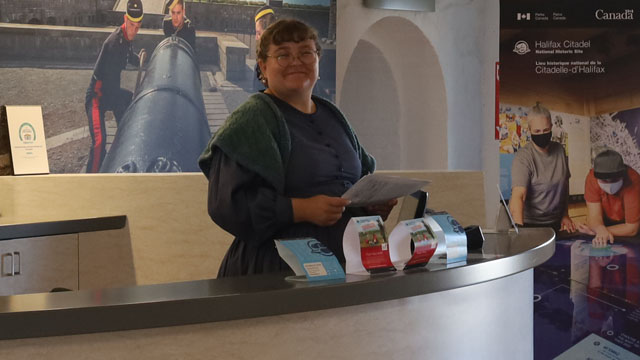 Le personnel en costume d’époque accueille les visiteurs au comptoir du centre d’information.