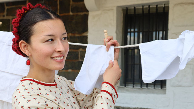 Person in a red bonnet and flowered dress.