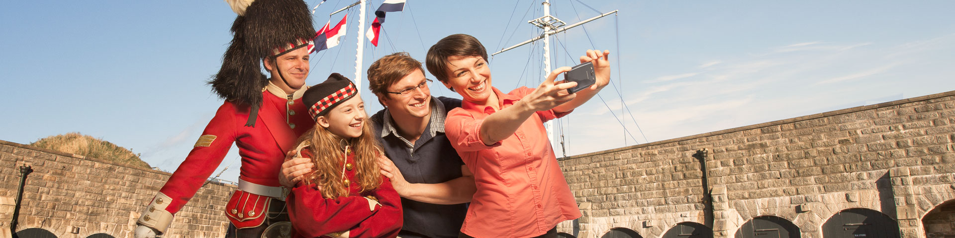 Un Highlander pose avec une famille pour un selfie.