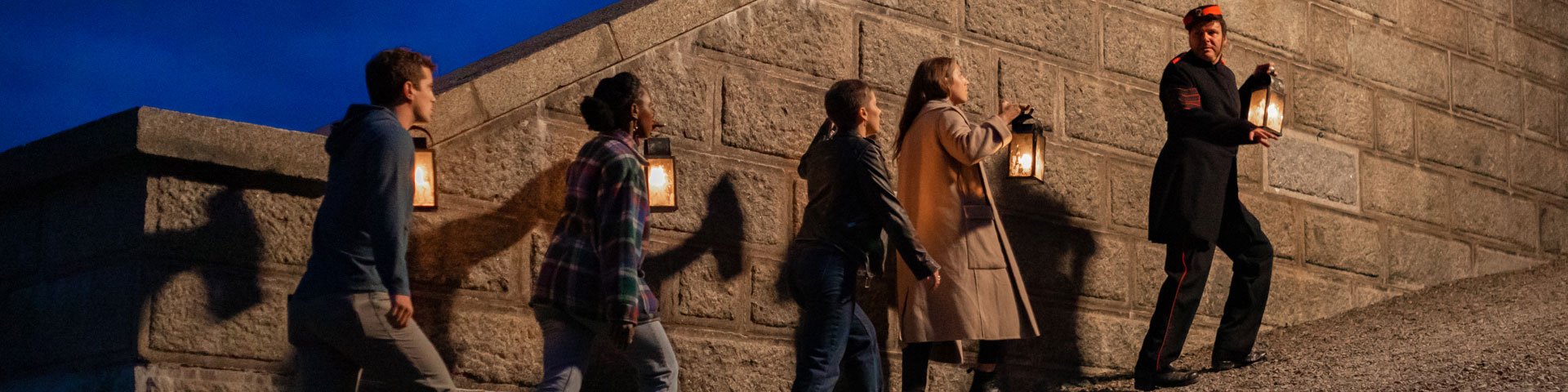 A group holding lanterns on a guided tour. 