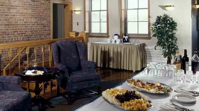 A table set up in the lobby with glasses, plates, and snacks.