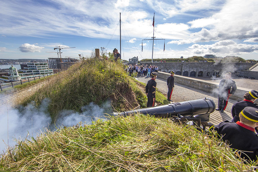 Smoke from the barrel and back of the Noon Gun after firing as soldiers wait for commands.