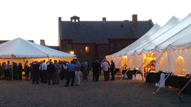 White tents with twinkle lights and lots of people.