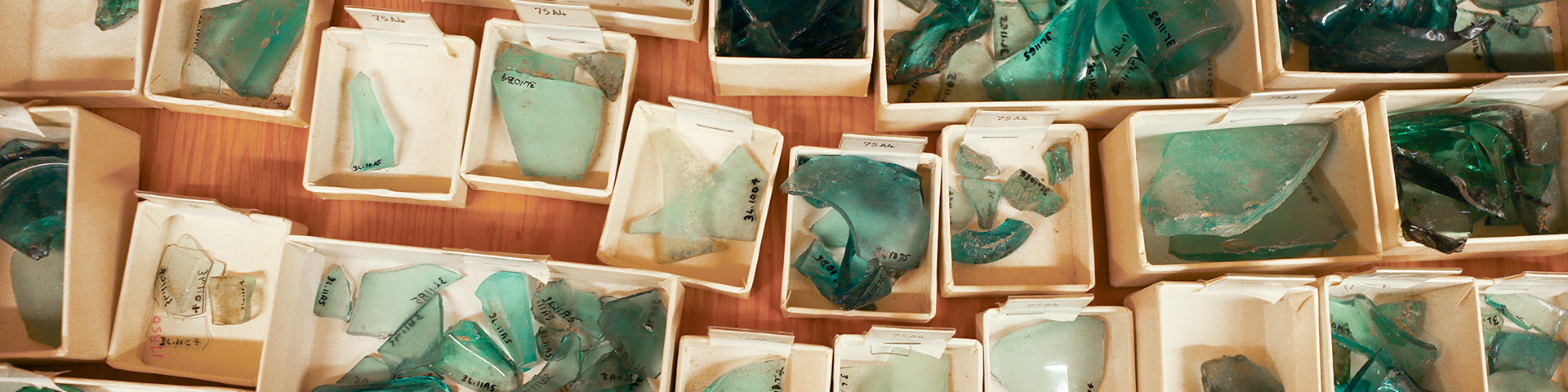 an overhead view of boxed turquoise glass artifacts in a collection