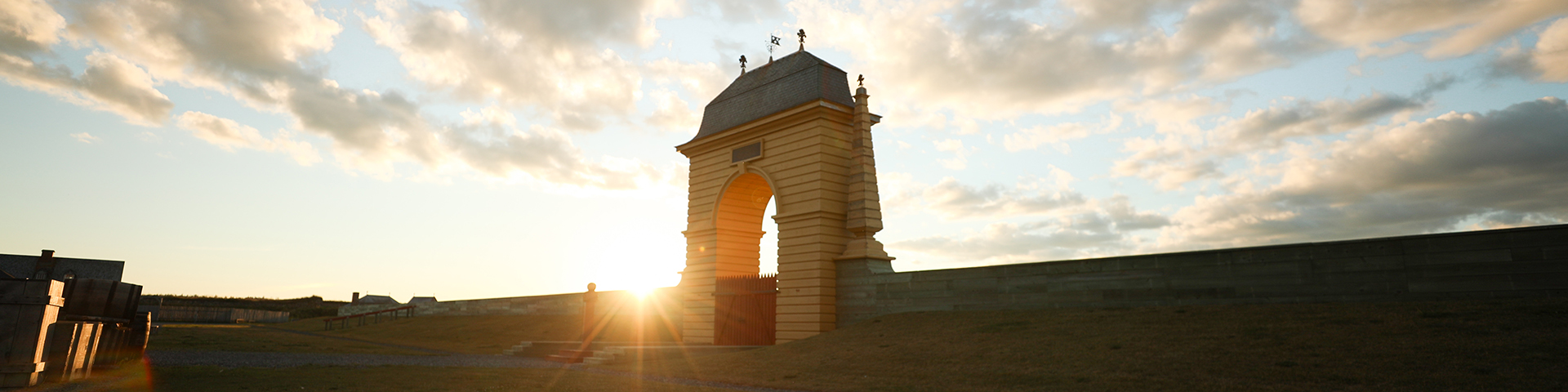 The Frederic Gate at dusk while the sun sets behind it on the left side