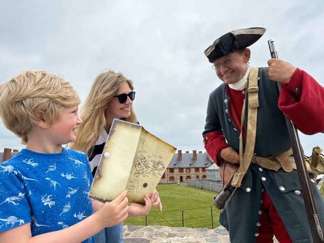 Les visiteurs interagissent avec un interprète en costume historique