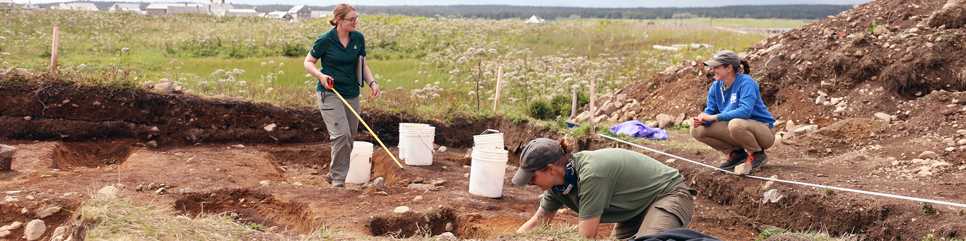 Someone sifting soil through a screen at an archaeological excavation site.