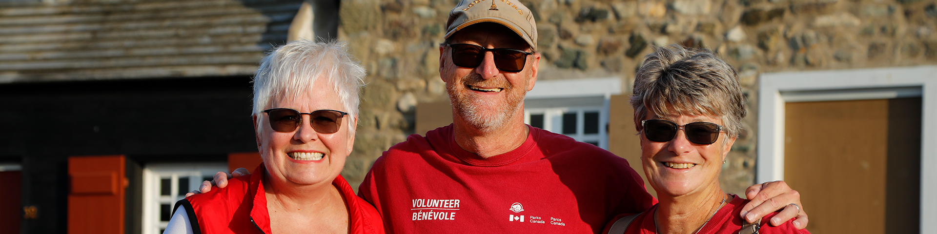 Three volunteers standing together and smiling.
