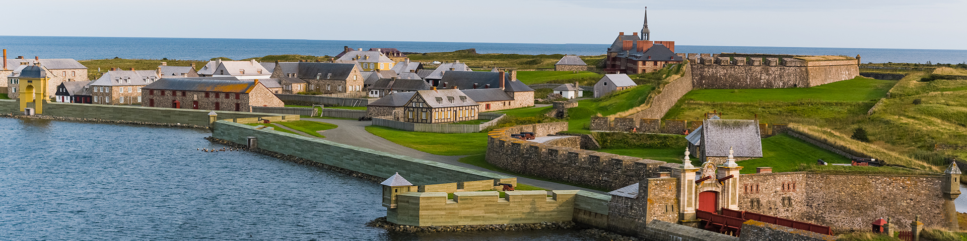 Aerial view of the Fortress of Louisbourg, showcasing its fortified walls, buildings, and surrounding landscape.
