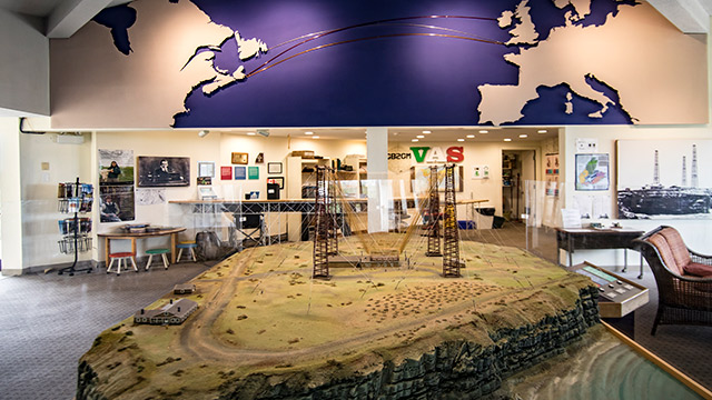 a model of radio towers are surrounded by museum infographics on a wall