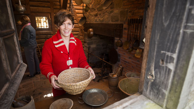 Visitors exploring historic kitchen tools. 