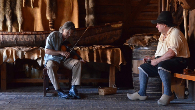 Un violoniste et un interprète costumé. 