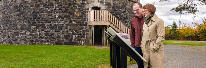 Two visitors read an interpretive panel.