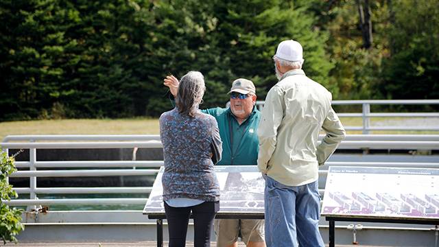 Un employé de Parcs Canada discute avec des visiteurs au lieu historique national du Canal-St-Peters.