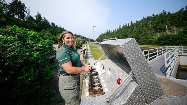 L'éclusier ouvre les écluses pour laisser passer un bateau.