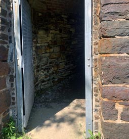 Porte métallique donnant sur un tunnel en briques.