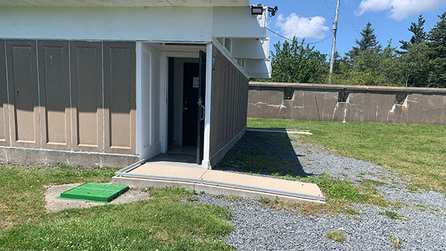 A short ramp leads from gravel to an open door.